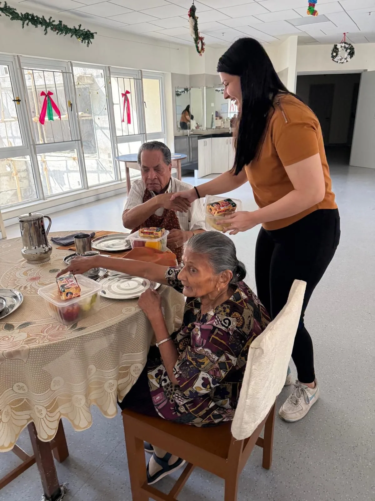 Riya handing rescued meal boxes to residents at a Food Connect partner home
